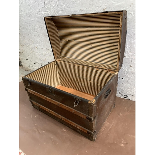 229 - An early 20th century black painted fibreboard and oak banded dome top travel trunk - approx. 55cm h... 