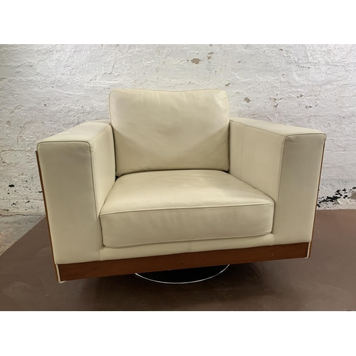 247 - A Dwell cream leather and walnut effect swivel arm chair - approx. 85cm high x 98cm wide x 88cm deep