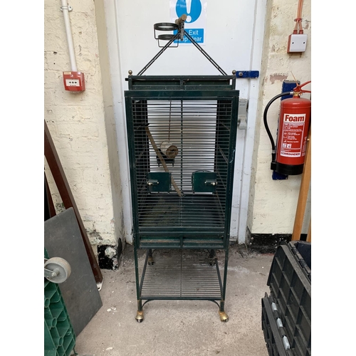 252 - A green painted metal bird cage on castors - approx. 149cm high x 46cm wide x 51cm deep