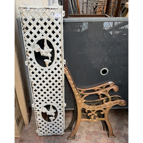 254 - Two cast iron garden bench accessories, one pair of bench ends and one back