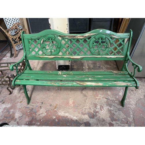 264 - A green painted wooden slatted and cast iron two seater garden bench - approx. 74cm high x 127cm wid... 