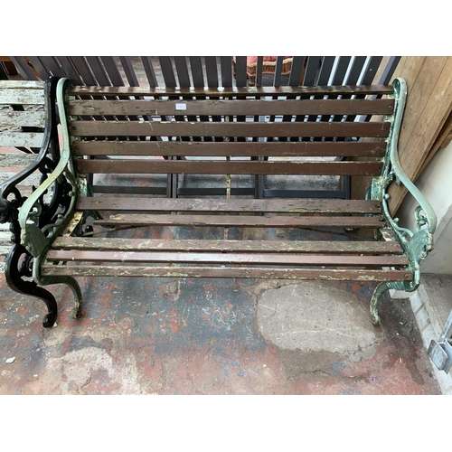 265 - A Victorian style cast iron and wooden slatted two seater garden bench - approx. 77cm high x 128cm w... 