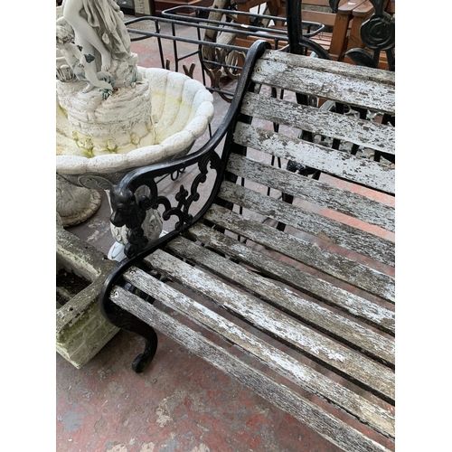 266 - A Victorian style cast iron and wooden slatted two seater garden bench - approx. 77cm high x 130cm w... 