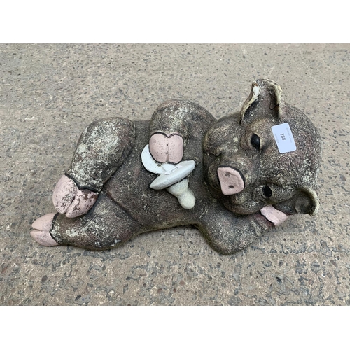 288 - A cast stone reclining pig garden ornament - approx. 42cm wide