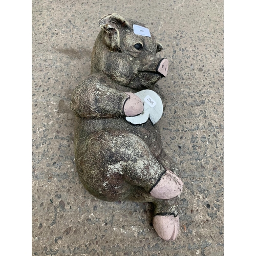 288 - A cast stone reclining pig garden ornament - approx. 42cm wide