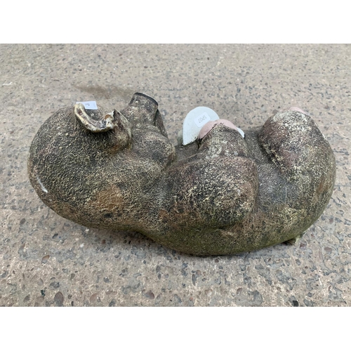 288 - A cast stone reclining pig garden ornament - approx. 42cm wide