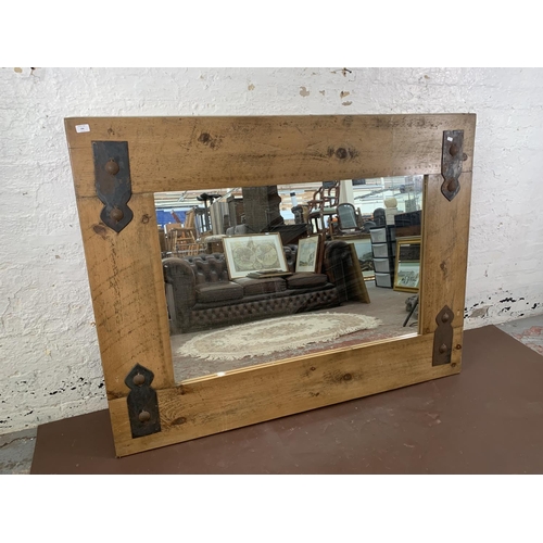 296 - A modern pine framed wall mirror with metal decoration - approx. 122cm high x 162cm wide