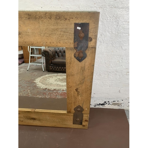 296 - A modern pine framed wall mirror with metal decoration - approx. 122cm high x 162cm wide