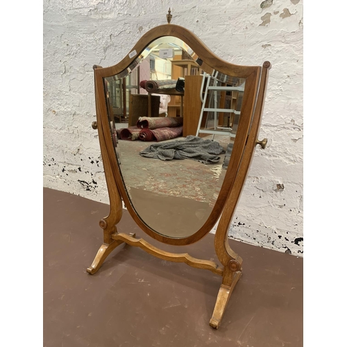 300 - An early 20th century Sheraton revival inlaid mahogany framed shield shaped swing dressing table mir... 