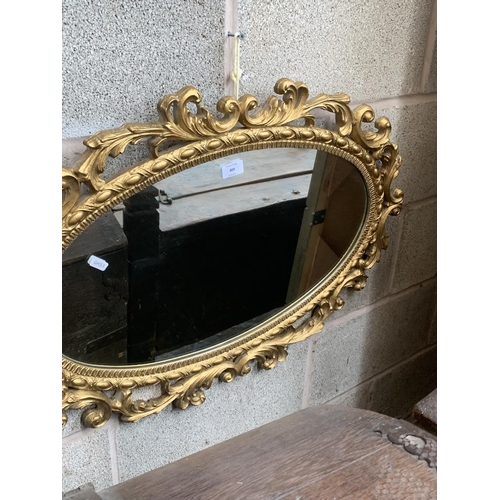 303 - A modern Rococo style oval gilt framed wall mirror - approx. 81cm high x 53cm wide