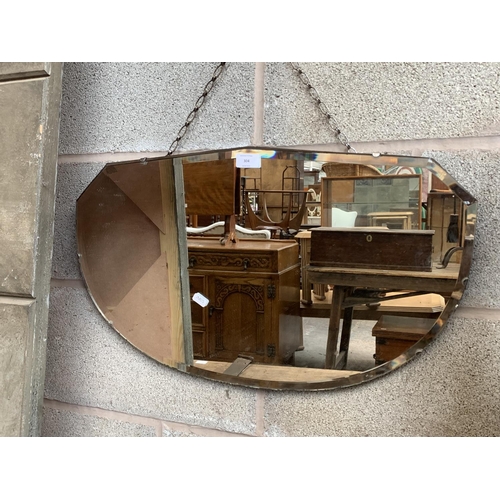 304 - A mid 20th century bevelled edge wall mirror - approx. 38cm high x 64cm wide