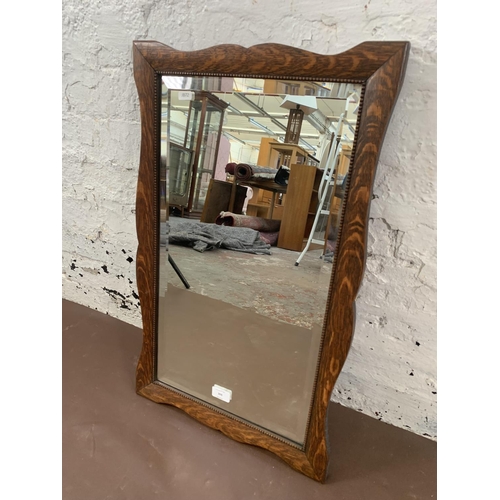 309 - An early 20th century oak framed bevelled edge wall mirror - approx. 62cm high x 42cm wide