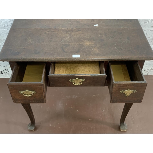 39 - A Georgian oak three drawer lowboy on cabriole supports - approx. 71cm high x 80cm wide x 55cm deep