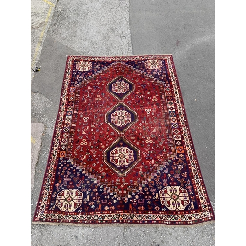 4 - A 20th century machine woven Shiraz rug - approx. 298cm x 210cm