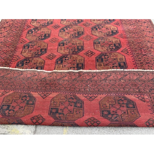 5 - A 20th century Afghan red ground rug - approx. 375cm x 285cm