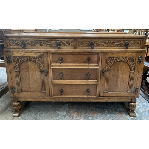 62 - A carved oak sideboard on baluster supports - approx. 88cm high x 134cm wide x 46cm deep