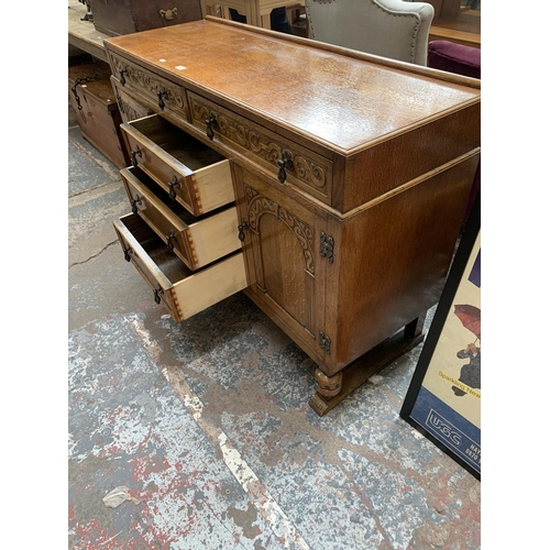 62 - A carved oak sideboard on baluster supports - approx. 88cm high x 134cm wide x 46cm deep