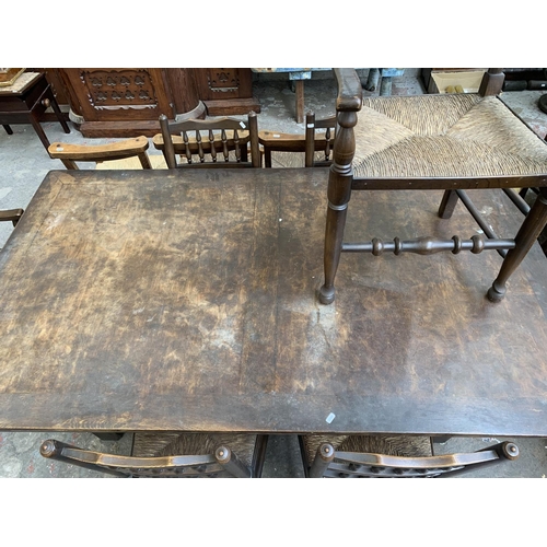 68 - A 17th century style solid oak refectory table and six Lancashire style elm and rush seated dining c... 