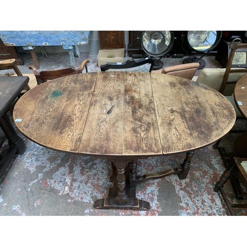 71 - A 17th century style oak drop leaf gate leg oval dining table - approx. 75cm high x 90cm wide x 150c... 