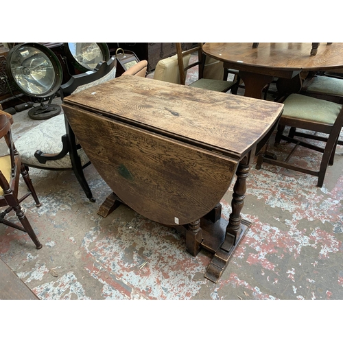 71 - A 17th century style oak drop leaf gate leg oval dining table - approx. 75cm high x 90cm wide x 150c... 