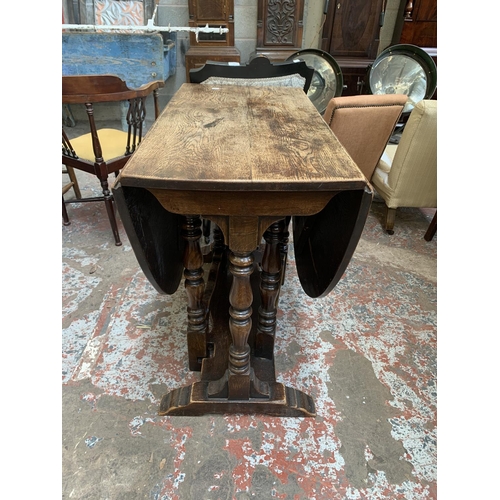 71 - A 17th century style oak drop leaf gate leg oval dining table - approx. 75cm high x 90cm wide x 150c... 