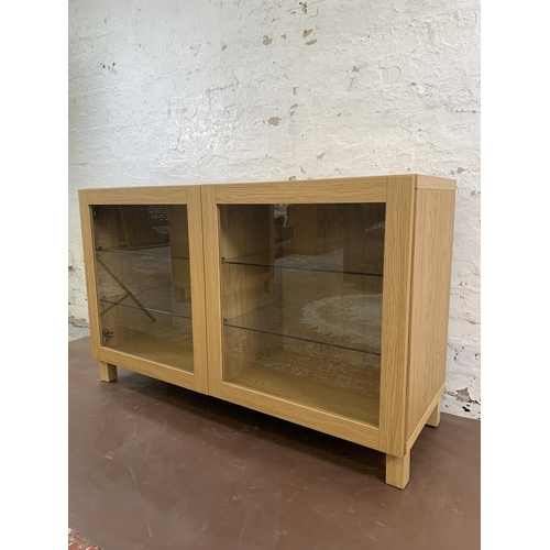 79 - An IKEA oak effect two door display cabinet - approx. 74cm high x 120cm wide x 41cm deep