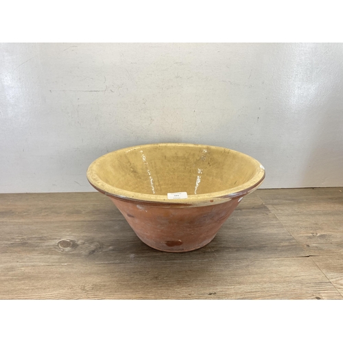 501 - A 19th century terracotta and cream glazed dairy bowl - approx. 20cm high x 45cm diameter