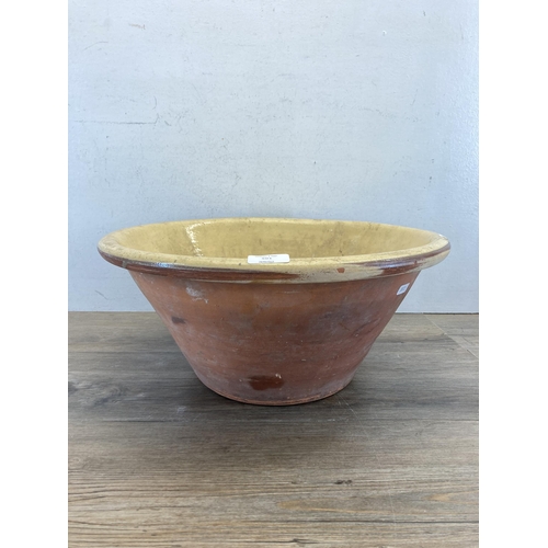 501 - A 19th century terracotta and cream glazed dairy bowl - approx. 20cm high x 45cm diameter