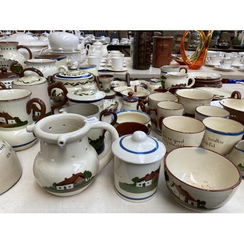 516 - A large collection of Torquay pottery/mottoware to include teapots, water jugs, teacups, serving dis... 