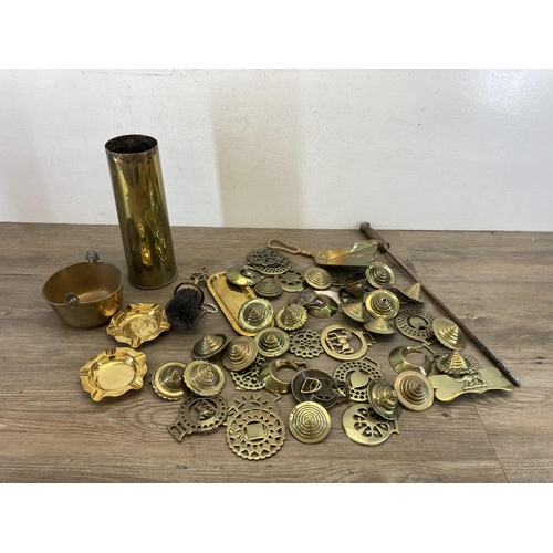 536 - A collection of 19th century and later brassware to include horse brasses, shell case, fire poker et... 