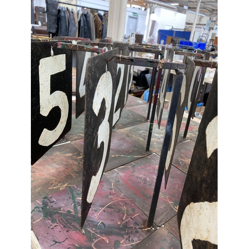 551 - Twenty three vintage hand-painted on steel cricket numbers on bespoke wrought iron stands - approx. ... 