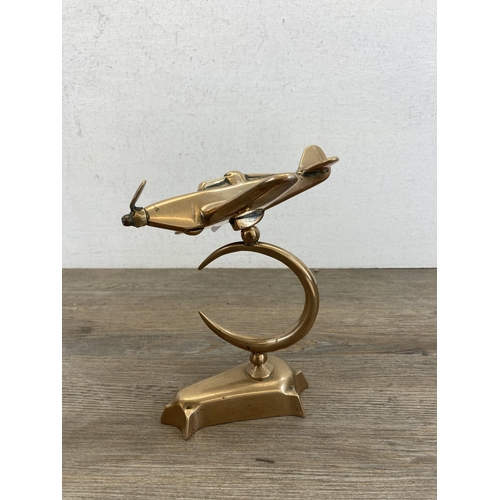 560 - Two items, one handmade brass aeroplane desk ornament and one SV & N brass shell case - approx. 15cm... 