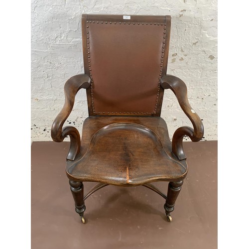 199 - A 19th century Holland & Sons mahogany and studded brown leather library chair with turned supports,... 