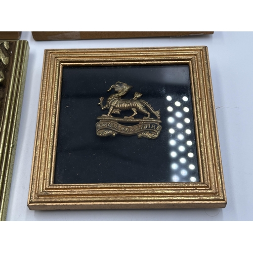 2093 - Four framed military cap badges