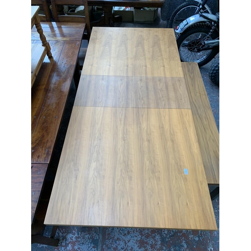 105 - A Dwell walnut effect and brushed steel crossed leg extendable dining table with bench - approx. 75c... 