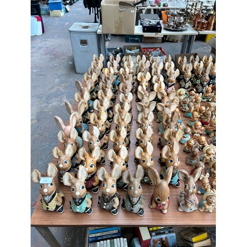 518 - An extensive collection of Pendelfin rabbit figurines and display stands to include Daisy Duck, Coll... 