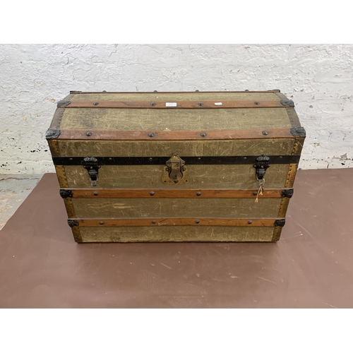 73 - An early 20th century green canvas and wooden banded dome top travel trunk - approx. 56cm high x 84c... 