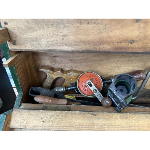 1051 - A vintage carpenter’s tool chest containing Spear & Jackson hand saws, Stanley hand drill, Record no... 