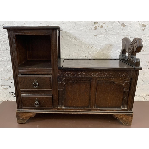 112 - A vintage oak telephone table with carved lion armrest, storage chest and two drawers - approx. 73cm... 