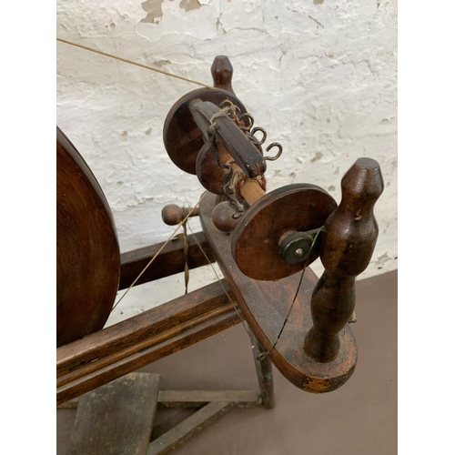 131 - A 19th century style stained wooden spinning wheel - approx. 86cm high