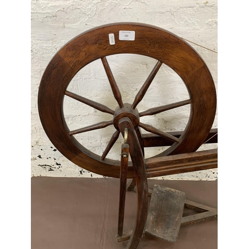 131 - A 19th century style stained wooden spinning wheel - approx. 86cm high