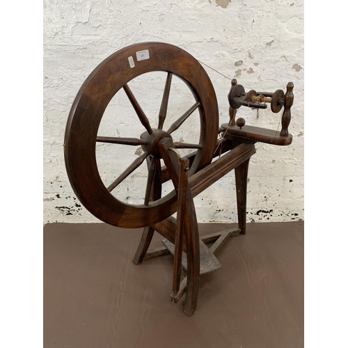 131 - A 19th century style stained wooden spinning wheel - approx. 86cm high