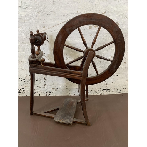 131 - A 19th century style stained wooden spinning wheel - approx. 86cm high