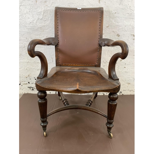 132 - A 19th century Holland & Sons mahogany and studded brown leather library chair with turned supports,... 