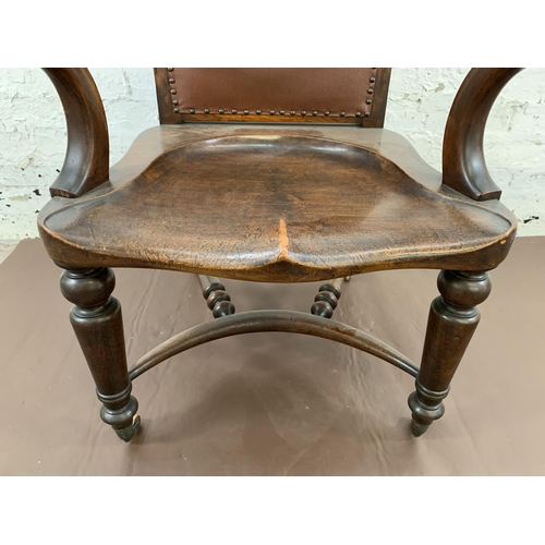 132 - A 19th century Holland & Sons mahogany and studded brown leather library chair with turned supports,... 