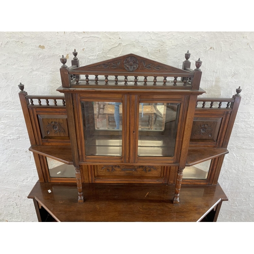 2 - An Edwardian mahogany mirrored back display cabinet with five shelves, two carved panel doors, one d... 