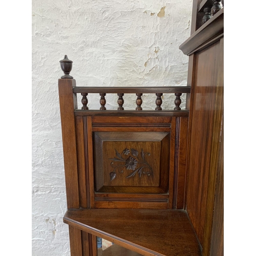 2 - An Edwardian mahogany mirrored back display cabinet with five shelves, two carved panel doors, one d... 