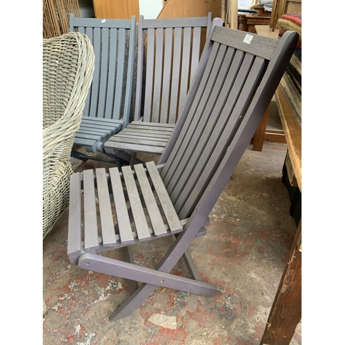 20 - Five pieces of furniture, three wooden grey painted folding garden chairs, one wicker armchair and o... 