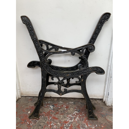 27 - A pair of cast iron and black painted garden bench ends