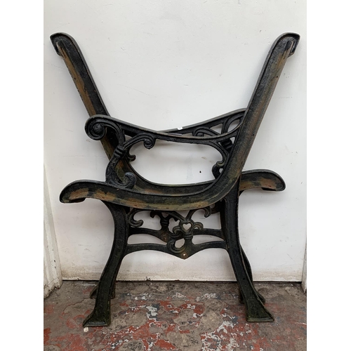 27 - A pair of cast iron and black painted garden bench ends